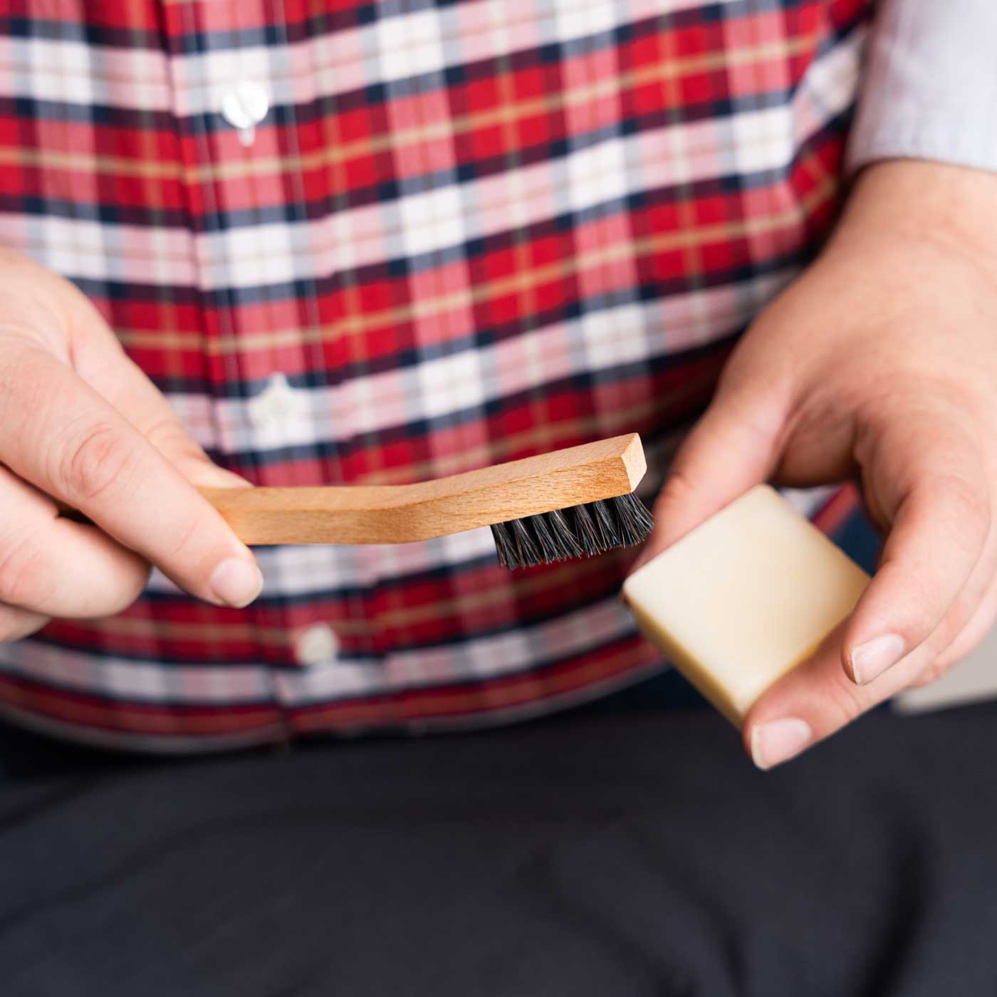 Man holding stain bar and horsehair brush brush